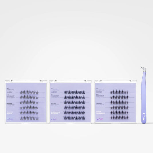 Three clear plastic lash extension trays filled with black false eyelash clusters, shown on a white background with a lavender tweezers tool standing to the right. The trays have a light lavender/purple tint.