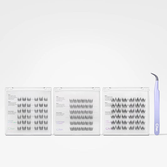 Three clear plastic lash trays containing black false eyelashes arranged in rows, with a light purple curved tweezor standing on the right side against a plain light gray background.