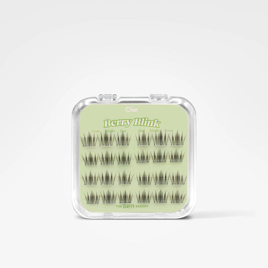 A clear plastic clamshell case containing multiple pairs of dark eyelash extensions arranged on a pale green insert card. The card shows the brand name 'Cute' and the product name 'berryBlink'.