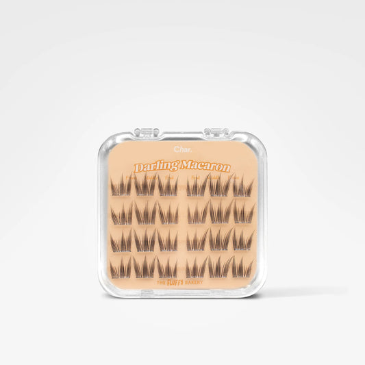 A clear plastic clamshell case containing 18 pairs of false eyelashes on a beige card labeled 'Daring Macaron' by The Bitter Batch, set against a clean white background.