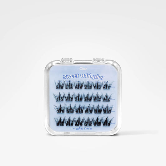 A clear plastic clamshell case containing five pairs of black false eyelashes on a light blue backing card labeled 'Sweet Whispers' and 'The Beauty Bank.'.