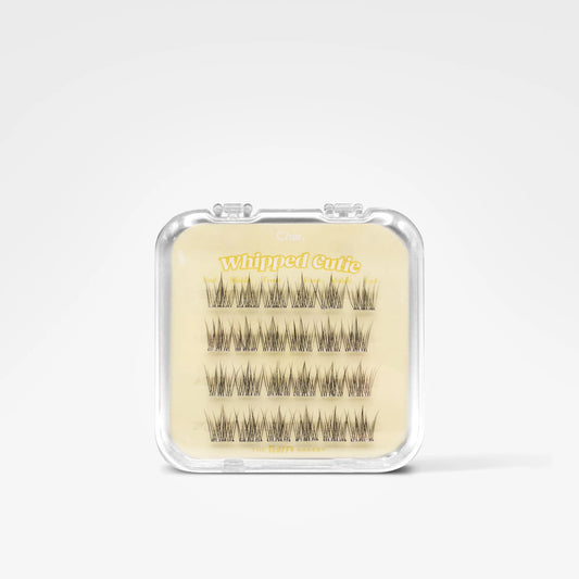 A clear plastic clamshell package containing multiple rows of black false eyelashes on a beige backing card with yellow text reading 'Whipped Curl'.