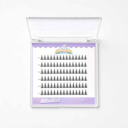 A clear plastic clamshell case containing multiple rows of black false eyelashes on a white insert card with a lavender border. The card shows the brand name 'Cotton Cloud' and a small carnival-themed logo.