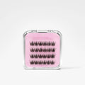 A pair of black false eyelashes in a clear plastic case with a pink insert labeled 'Blush Macaron' on a light gray background.