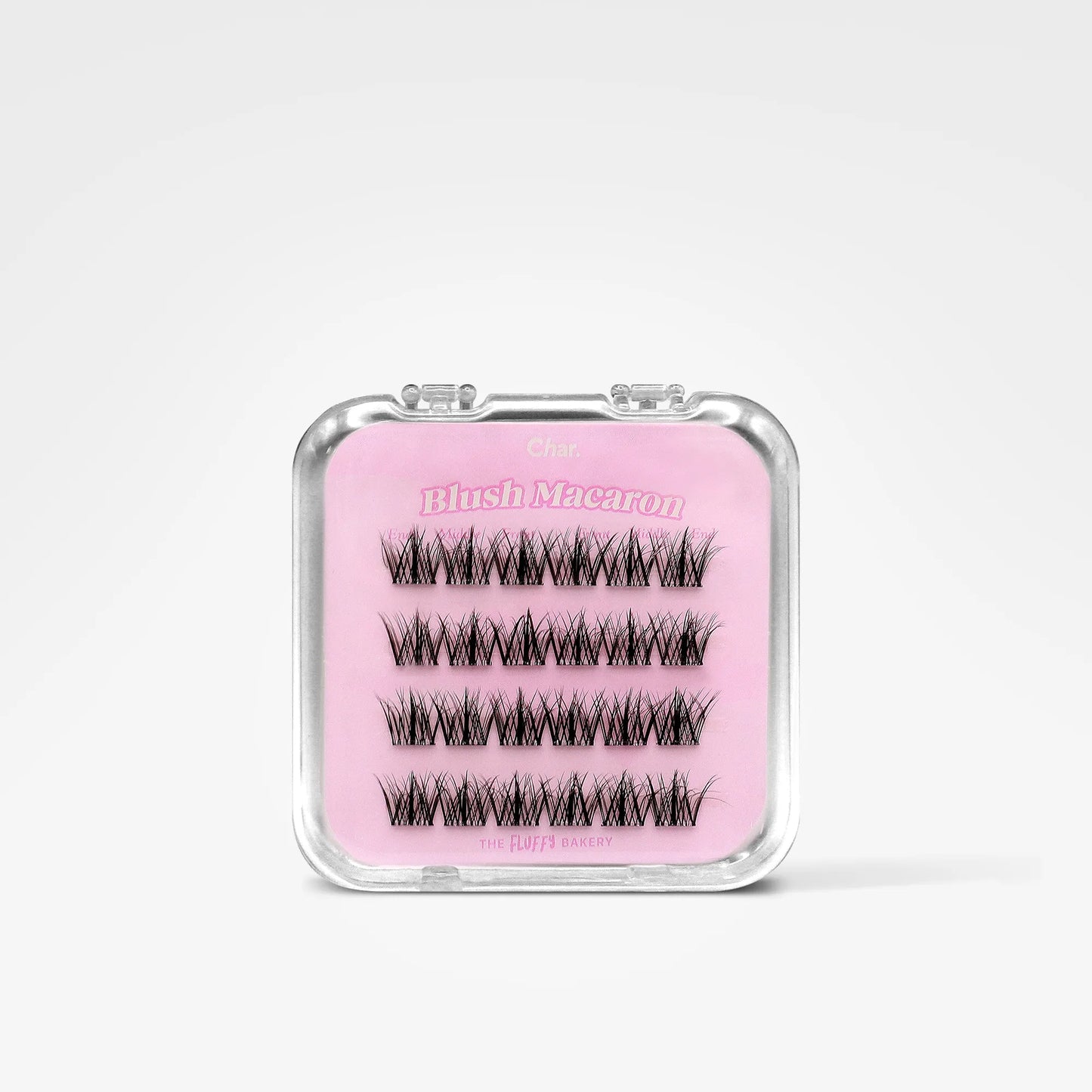 A pair of black false eyelashes in a clear plastic case with a pink insert labeled 'Blush Macaron' on a light gray background.