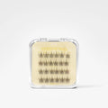 A clear plastic clamshell package containing multiple rows of black false eyelashes on a beige backing card with yellow text reading 'Whipped Curl'.