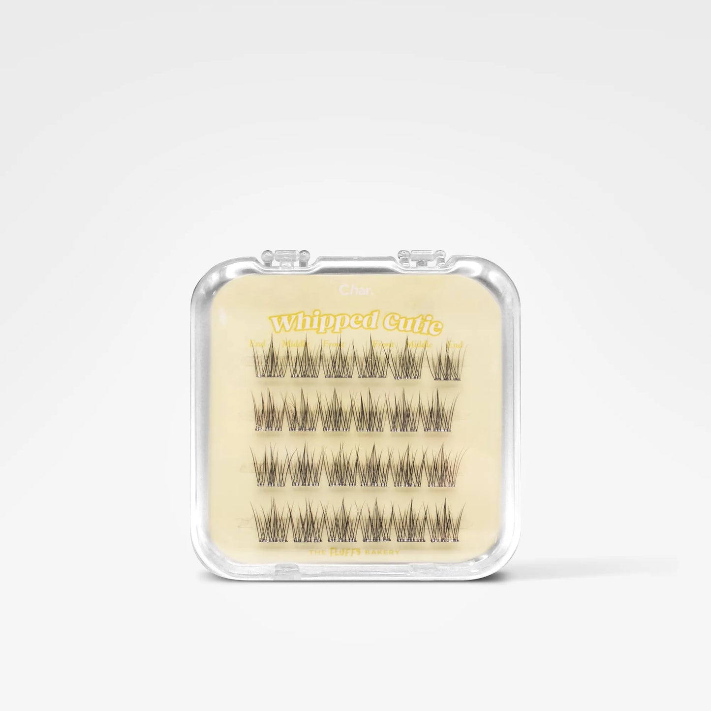 A clear plastic clamshell package containing multiple rows of black false eyelashes on a beige backing card with yellow text reading 'Whipped Curl'.
