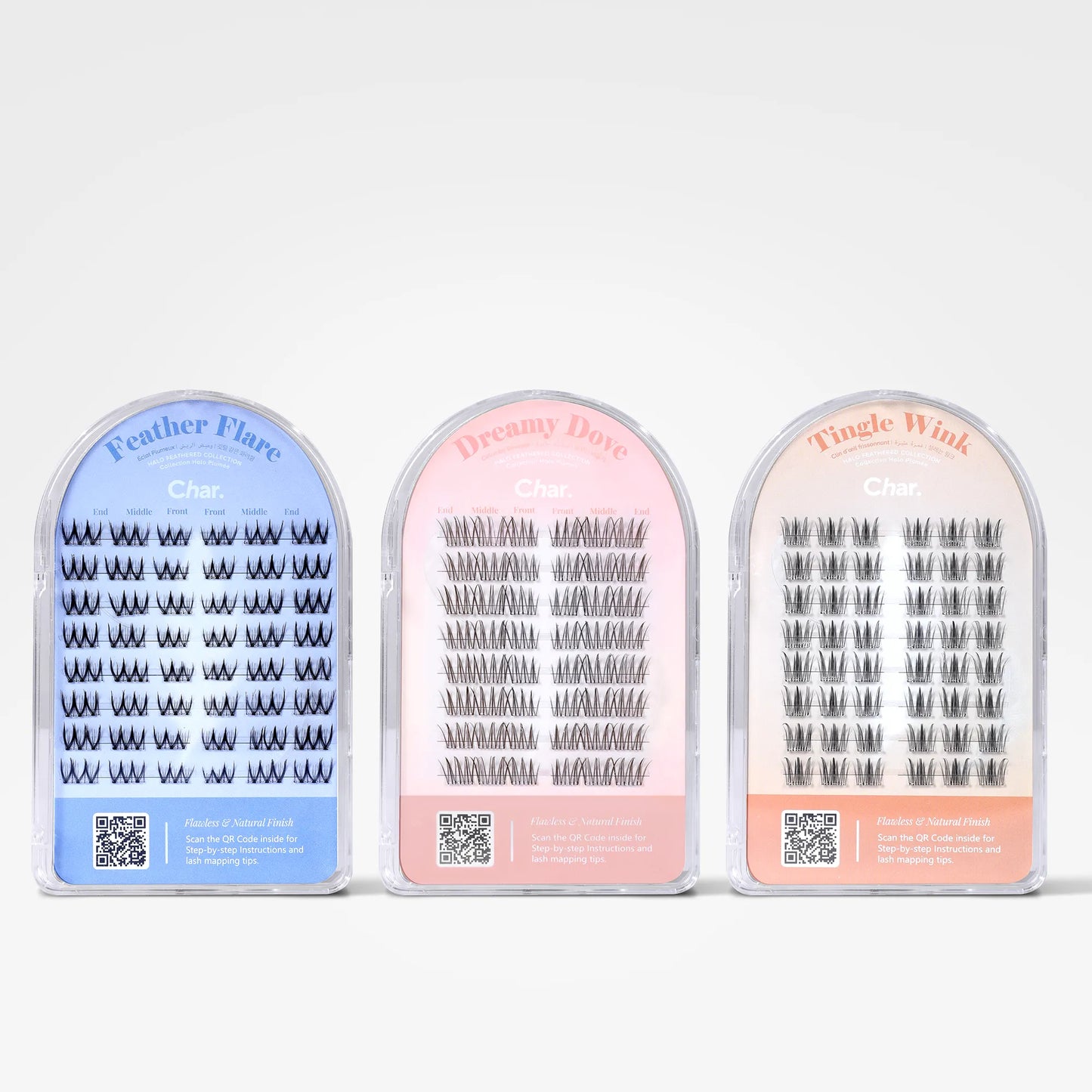 Three pairs of false eyelashes in arched packaging, shown side by side on a light gray background. The left package is light blue and labeled 'Feather Flare Char', the middle is pink and labeled 'Dreamy Dove Char', and the right is peach and labeled 'Tingie Wink Char'.